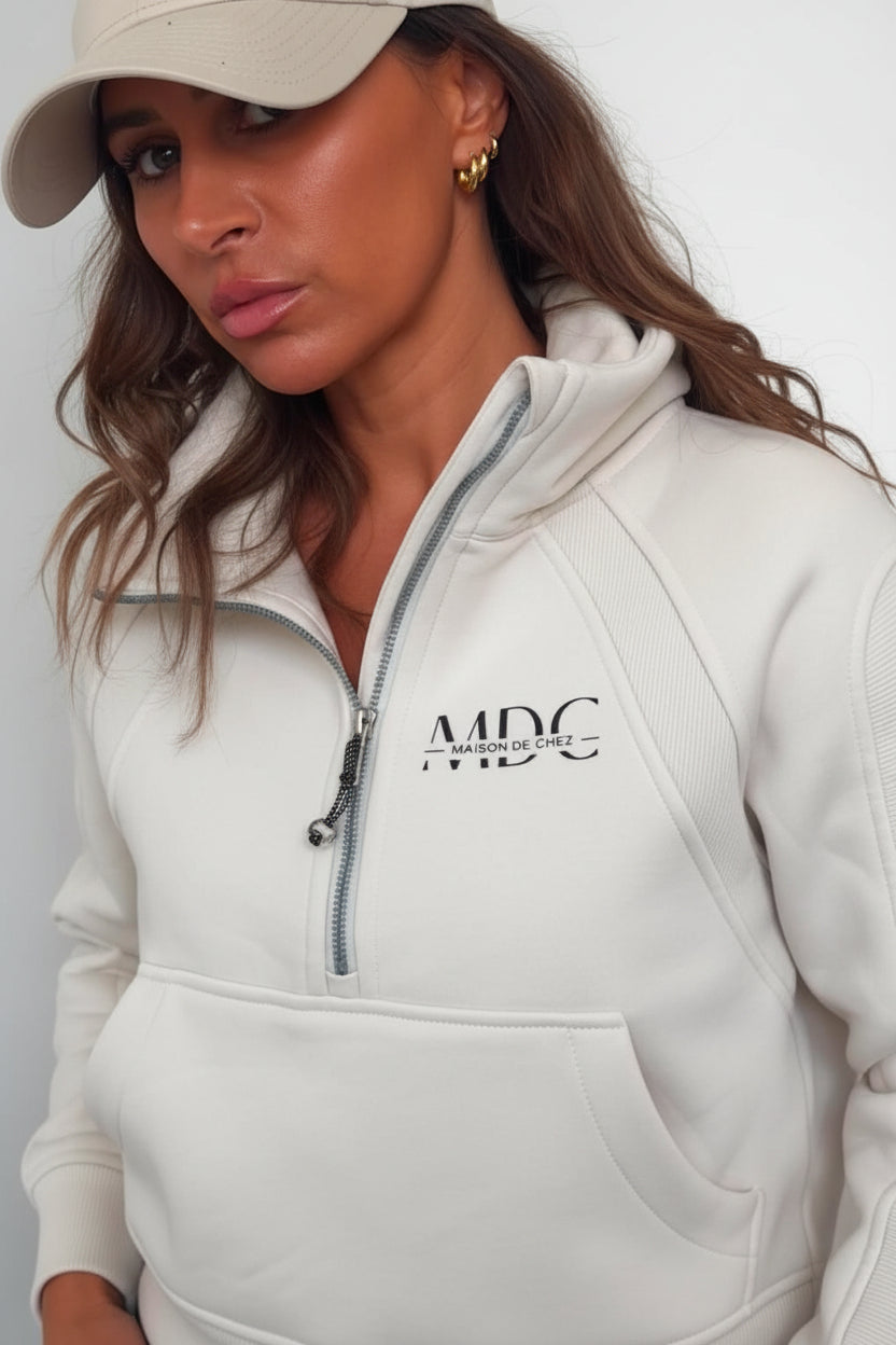 Person wearing a white hoodie with 'MDC' logo, looking down.